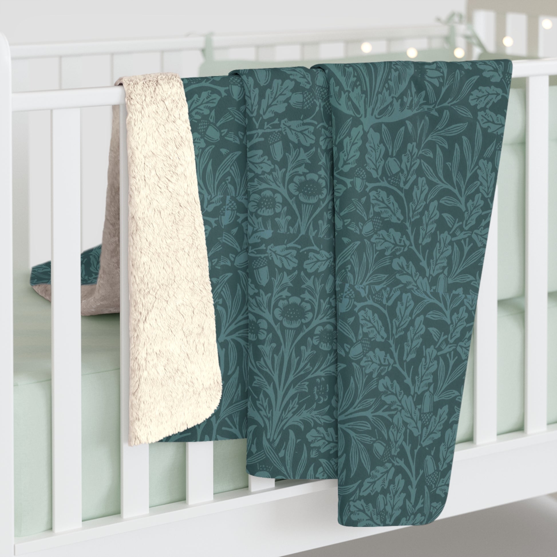 A rectangular Sherpa fleece blanket with a teal colour and a floral pattern inspired by William Morris - Acorns and Oak Trees Collection.