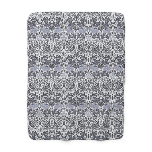 A grey Sherpa fleece blanket with a floral pattern, inspired by William Morris, from the Brer Rabbit collection.