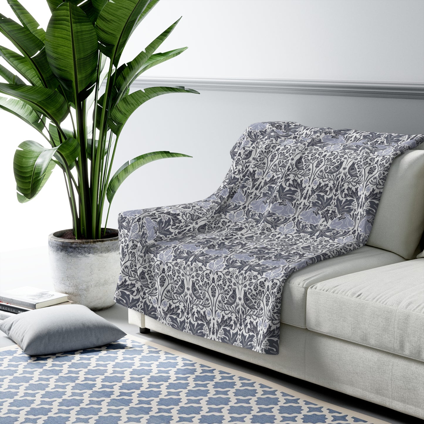 A grey Sherpa fleece blanket with a floral pattern, inspired by William Morris, from the Brer Rabbit collection.