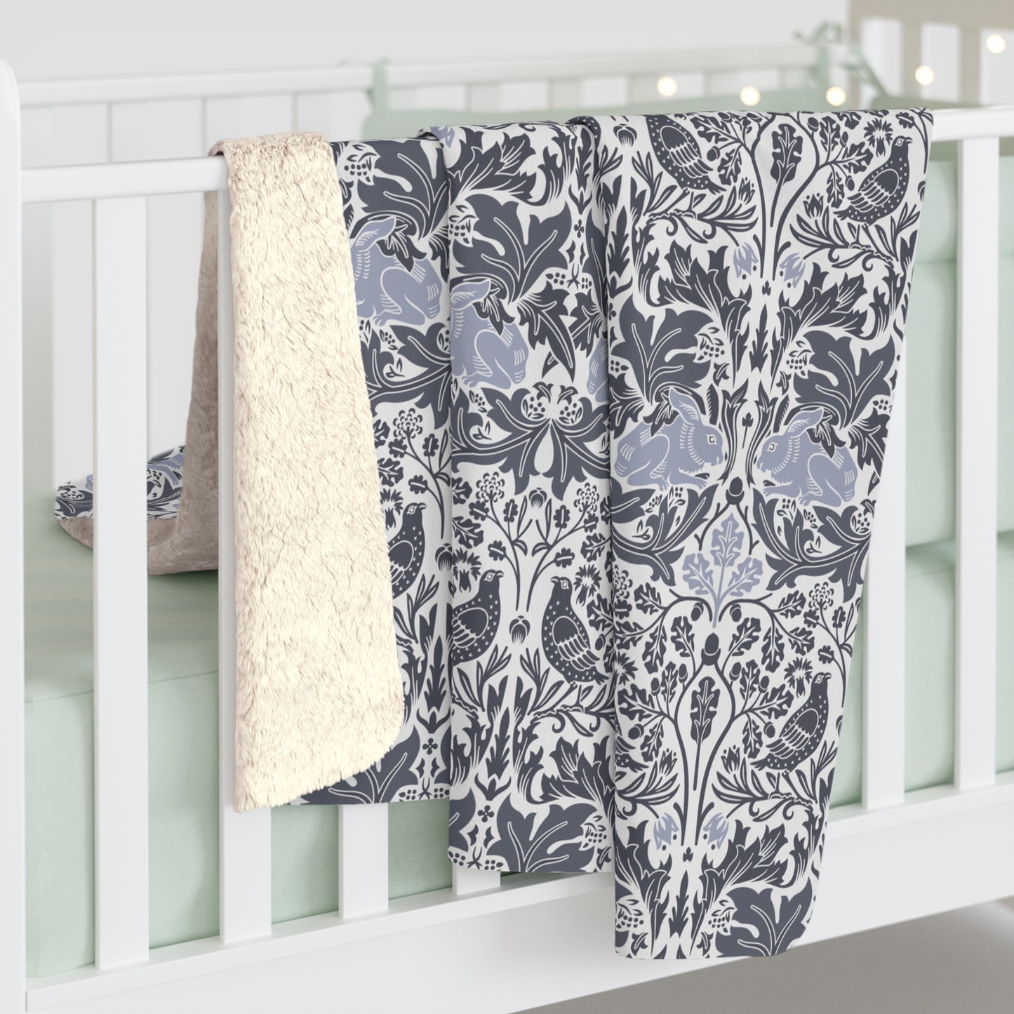 A grey Sherpa fleece blanket with a floral pattern, inspired by William Morris, from the Brer Rabbit collection.