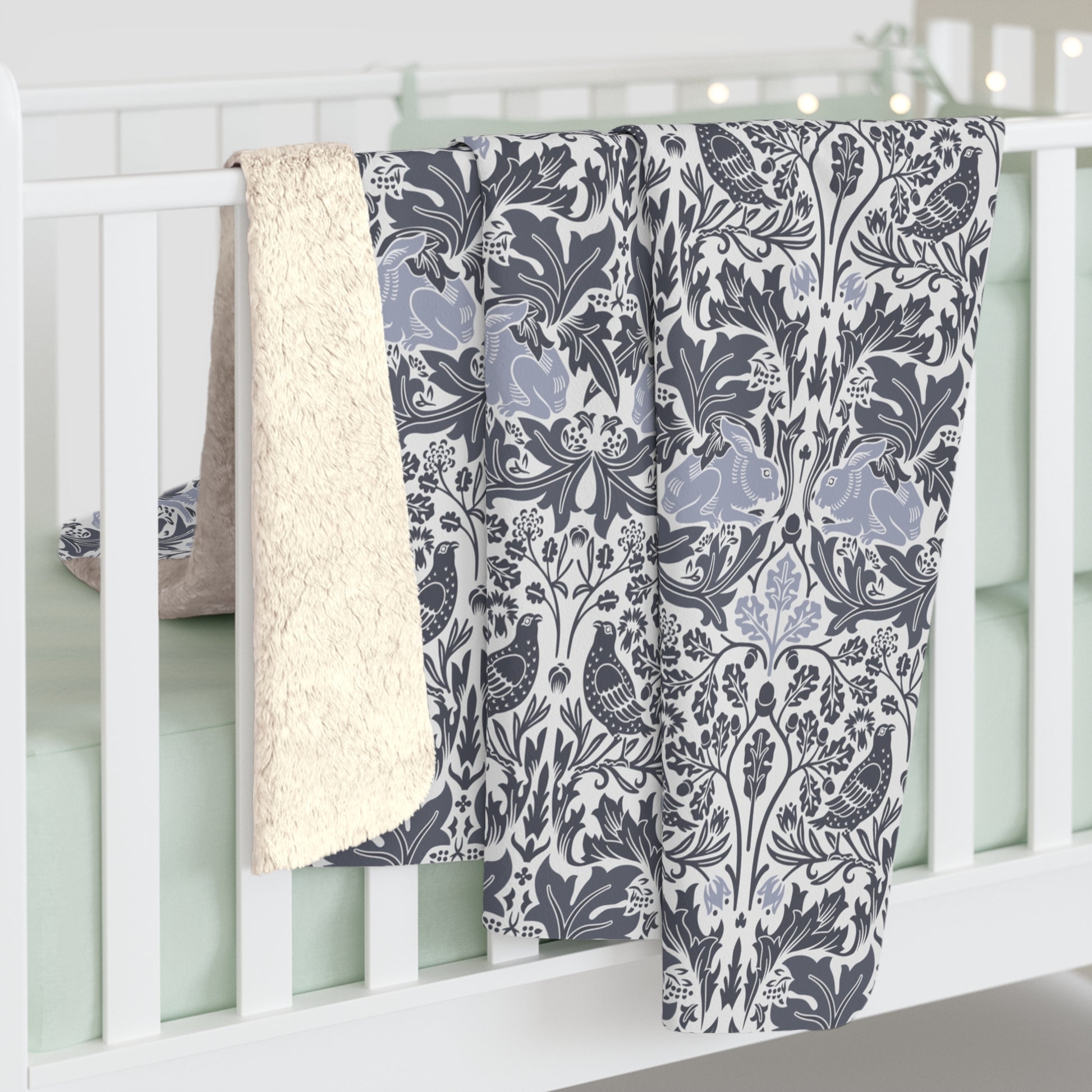 A grey Sherpa fleece blanket with a floral pattern, inspired by William Morris, from the Brer Rabbit collection.