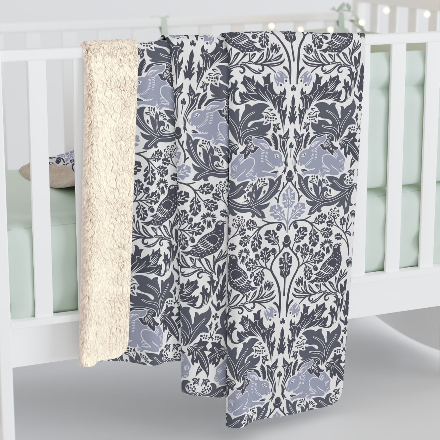 A grey Sherpa fleece blanket with a floral pattern, inspired by William Morris, from the Brer Rabbit collection.