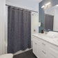 Bathroom with white vanity, gray shower curtain, and blue walls.