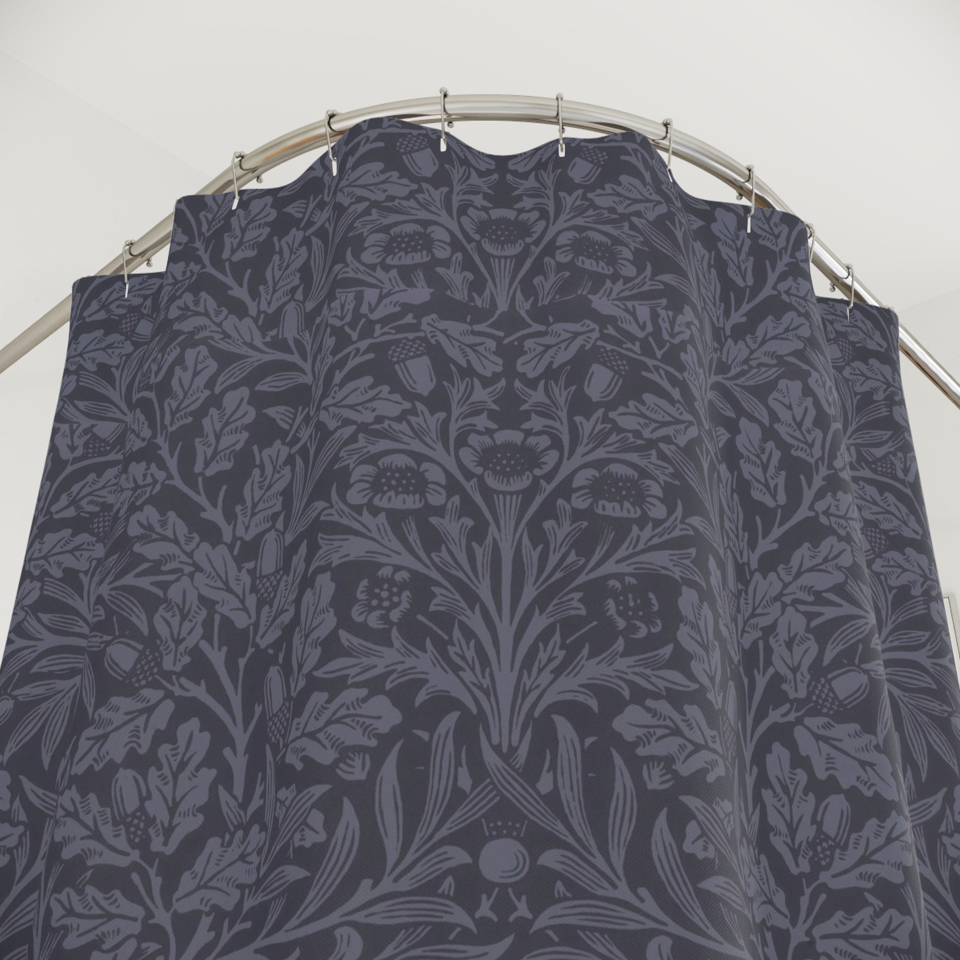 Dark floral patterned fabric on a metal rod against a white background