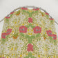 Floral patterned garment on a hanger against a white background