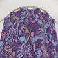 Floral patterned fabric on a metal rod against a white background