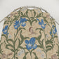 Floral and bird patterned fabric on a hanger against a white background