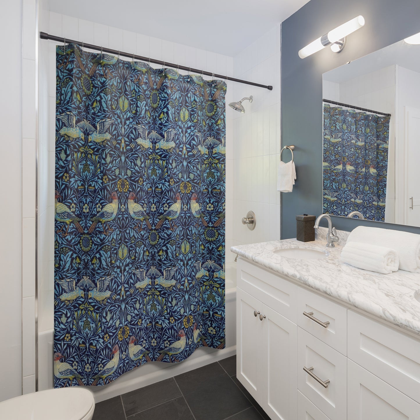 A shower curtain with a blue floral pattern inspired by William Morris, featuring birds and butterflies, displayed on a white background.