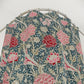 Floral patterned shower curtain on a hanger against a white background