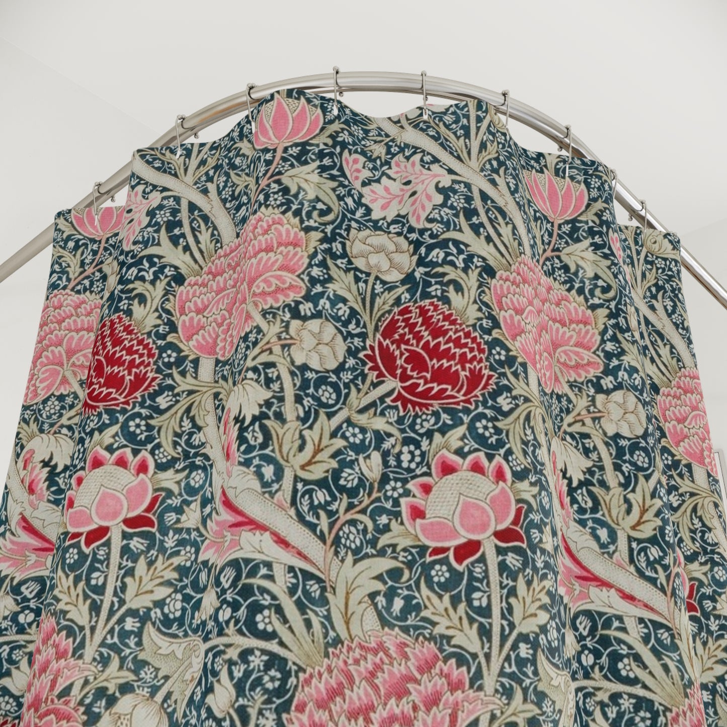 Floral patterned shower curtain on a hanger against a white background