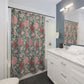 Bathroom with floral shower curtain, sink, and mirror.