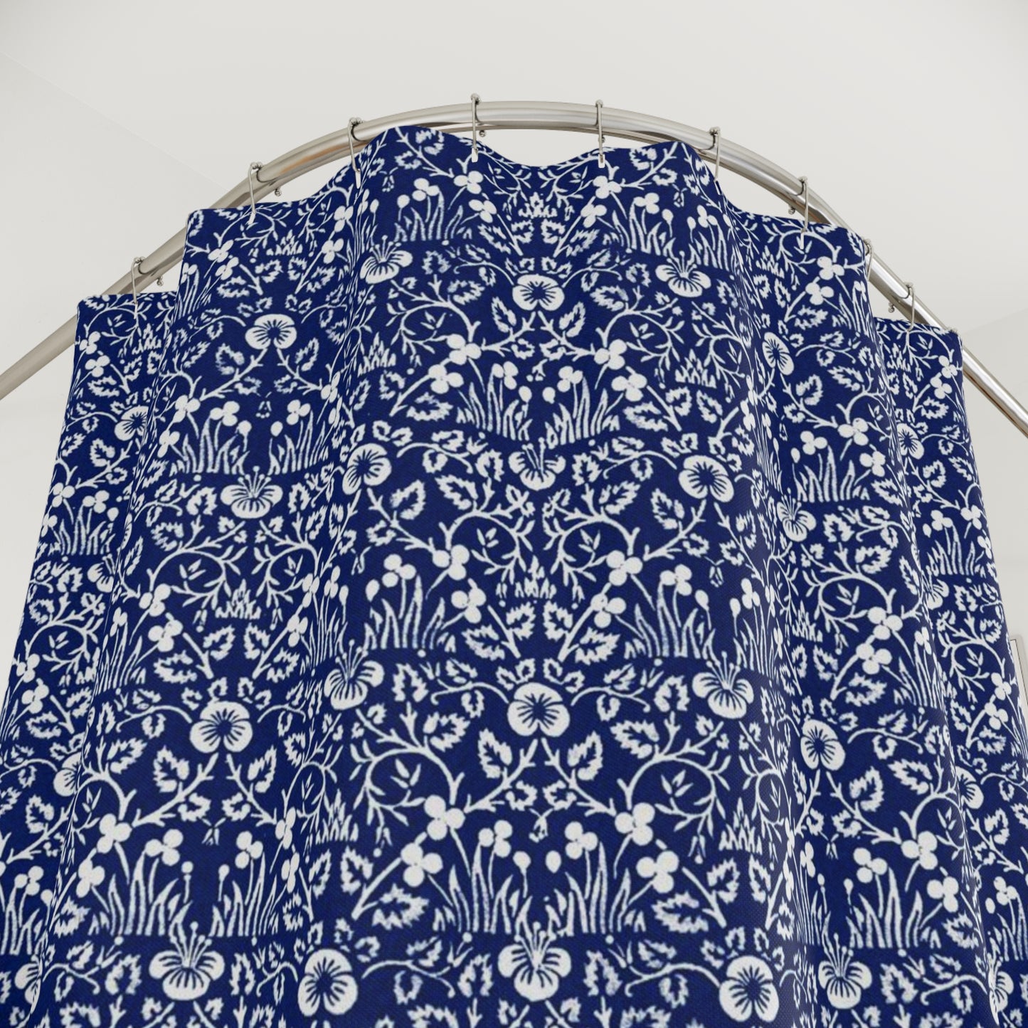 Blue fabric with white floral pattern draped over a circular metal stand on a white background
