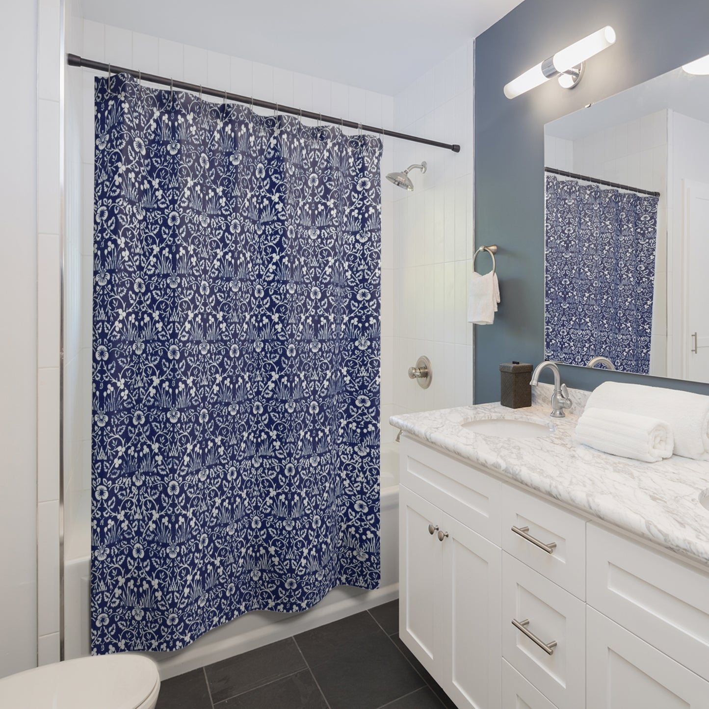 Bathroom with a blue floral shower curtain and white vanity.