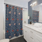 Bathroom with a floral-patterned shower curtain, white vanity, and mirror.