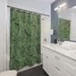 Bathroom with green leaf-patterned shower curtain and white vanity.