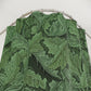 Green leaf-patterned fabric on a metal rod against a white background