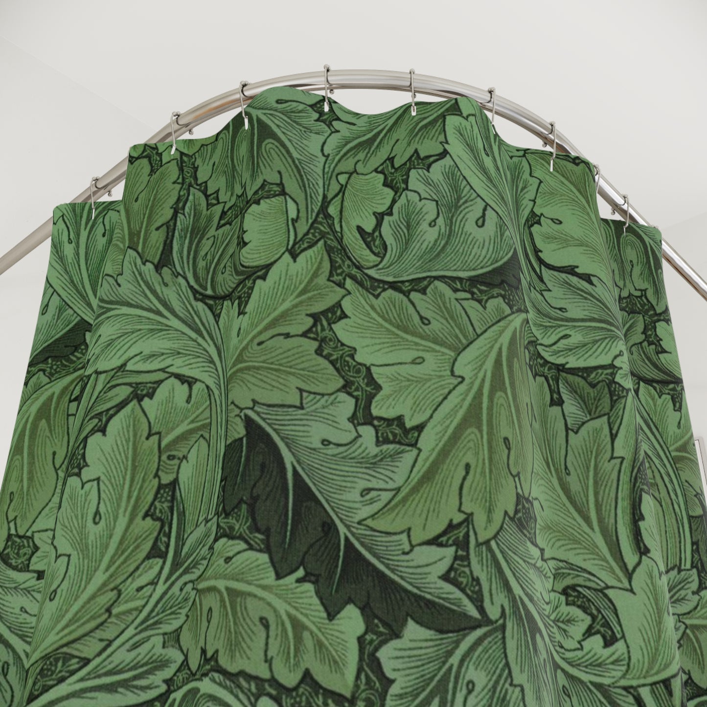 Green leaf-patterned fabric on a metal rod against a white background