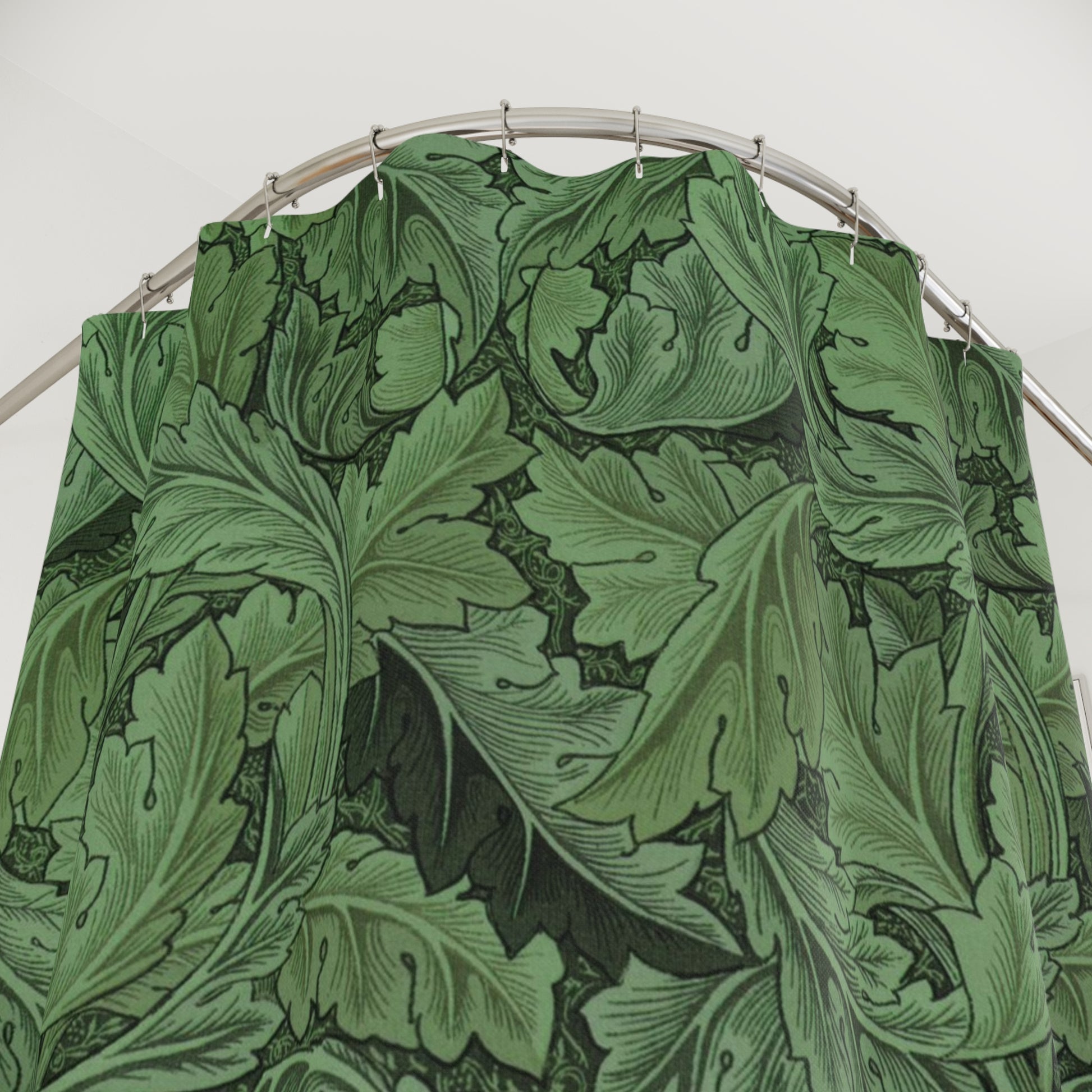 Green leaf-patterned fabric on a metal rod against a white background