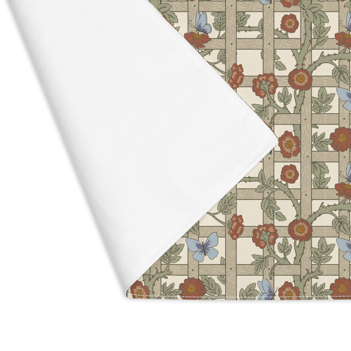 A folded sheet of white paper is shown over a patterned paper sample featuring a floral and lattice design in muted red, blue, green, and beige tones.