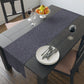 A smoky blue table runner with a William Morris & Co leaf pattern displayed on a dining table.