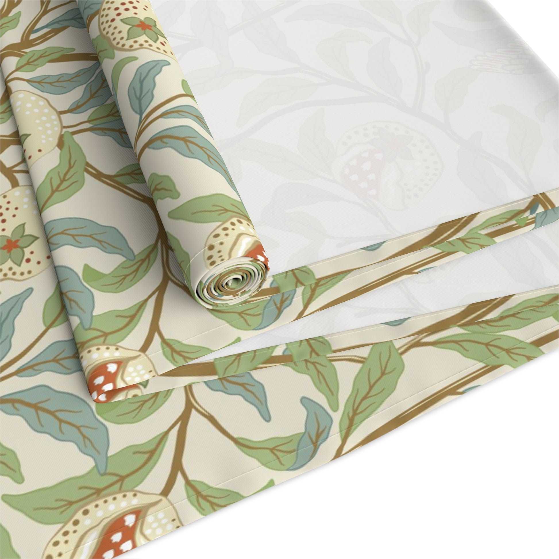 A table runner with a Victorian William Morris & Co floral design in green, blue, and brown colours, laid out on a dining table.