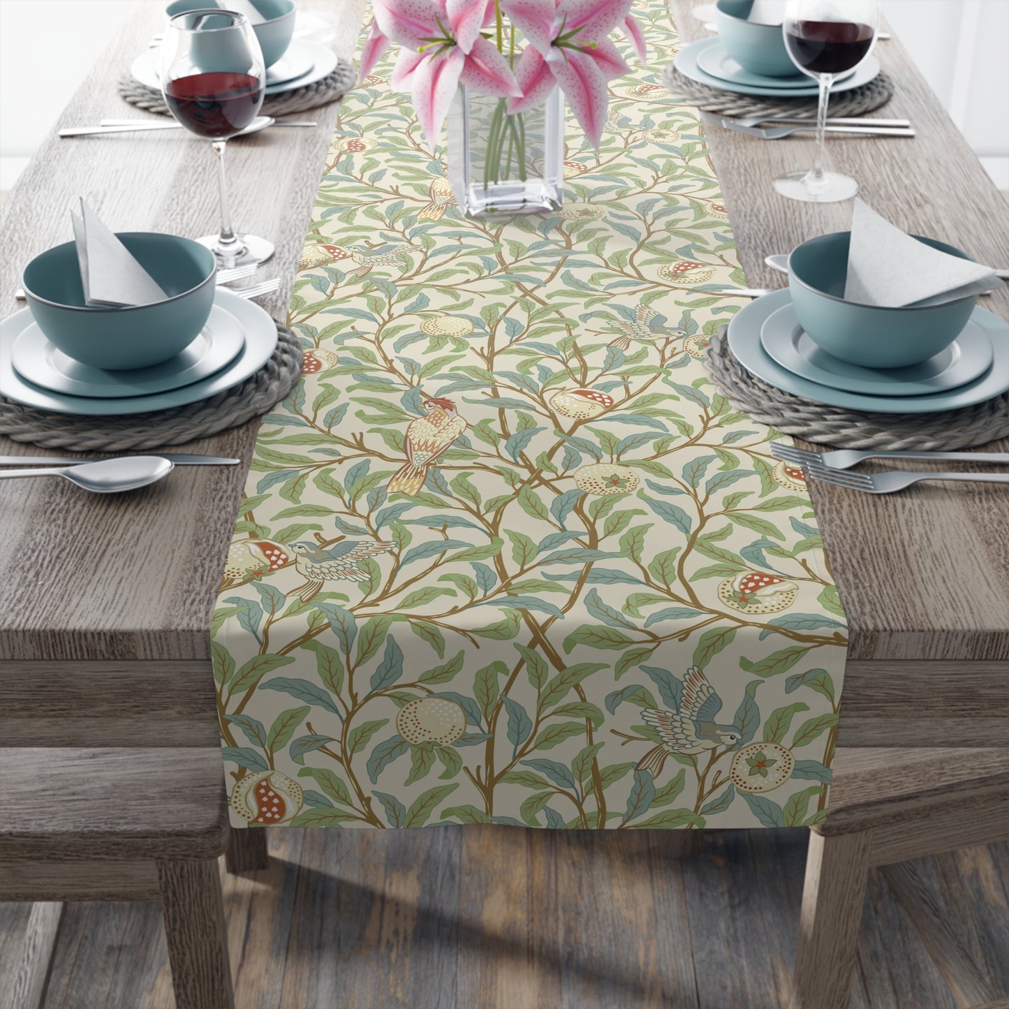 A table runner with a Victorian floral design in green, blue, and brown colors, laid out on a dining table.