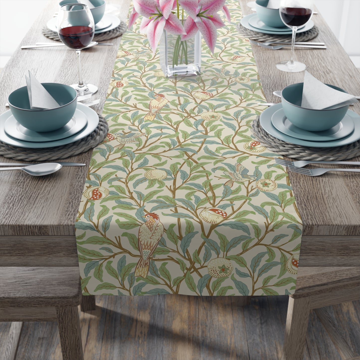 A table runner with a Victorian floral design in green, blue, and brown colors, laid out on a dining table.
