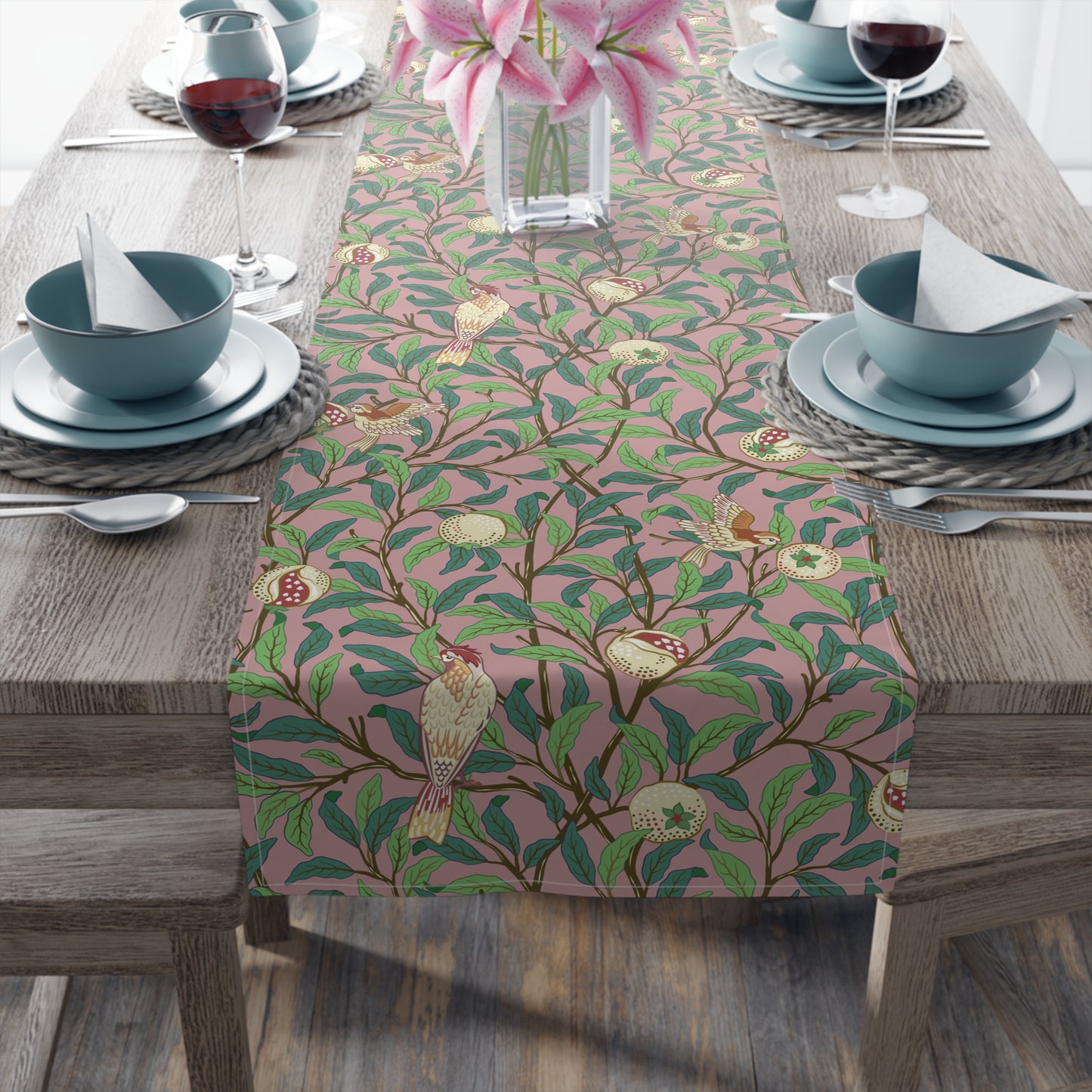 A table runner with a William Morris & Co Victorian-inspired bird and pomegranate pattern laid out on a dining table.