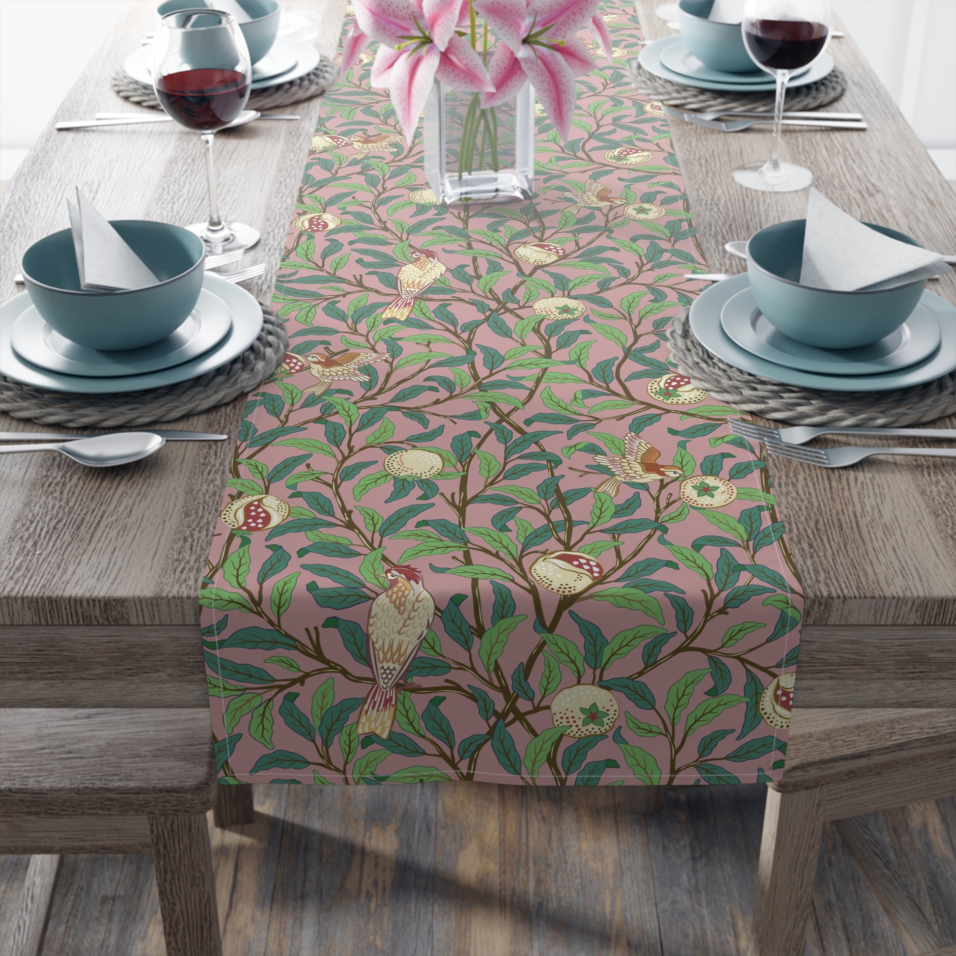A table runner with a William Morris & Co Victorian-inspired bird and pomegranate pattern laid out on a dining table.