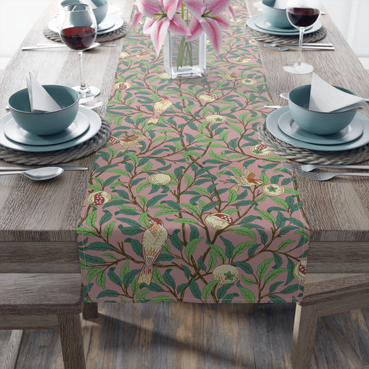 A table runner with a William Morris & Co Victorian-inspired bird and pomegranate pattern laid out on a dining table.