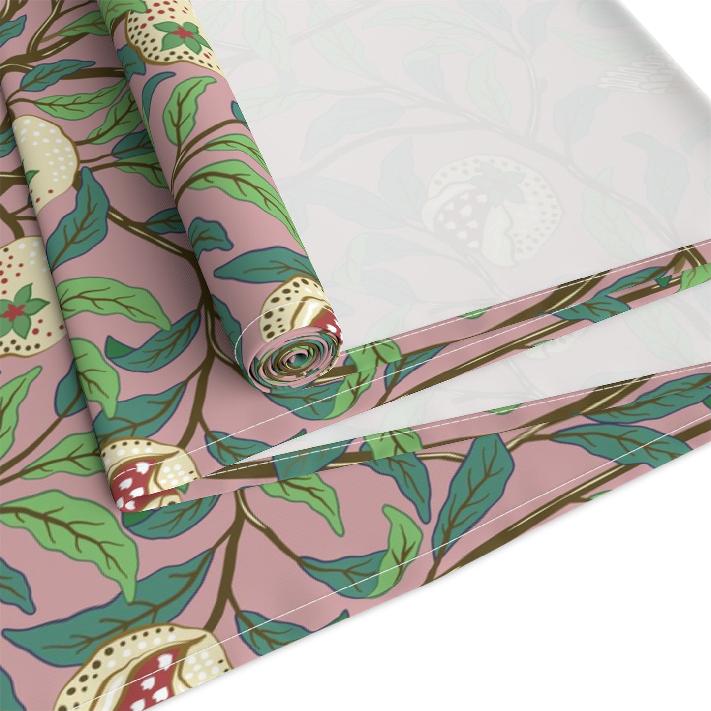 A table runner with a William Morris & Co Victorian-inspired bird and pomegranate pattern laid out on a dining table.