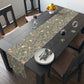 A table runner with a William Morris & Co Victorian-inspired bird and pomegranate pattern laid out on a dining table.