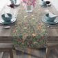 A table runner with a Victorian-inspired bird and pomegranate pattern laid out on a dining table.