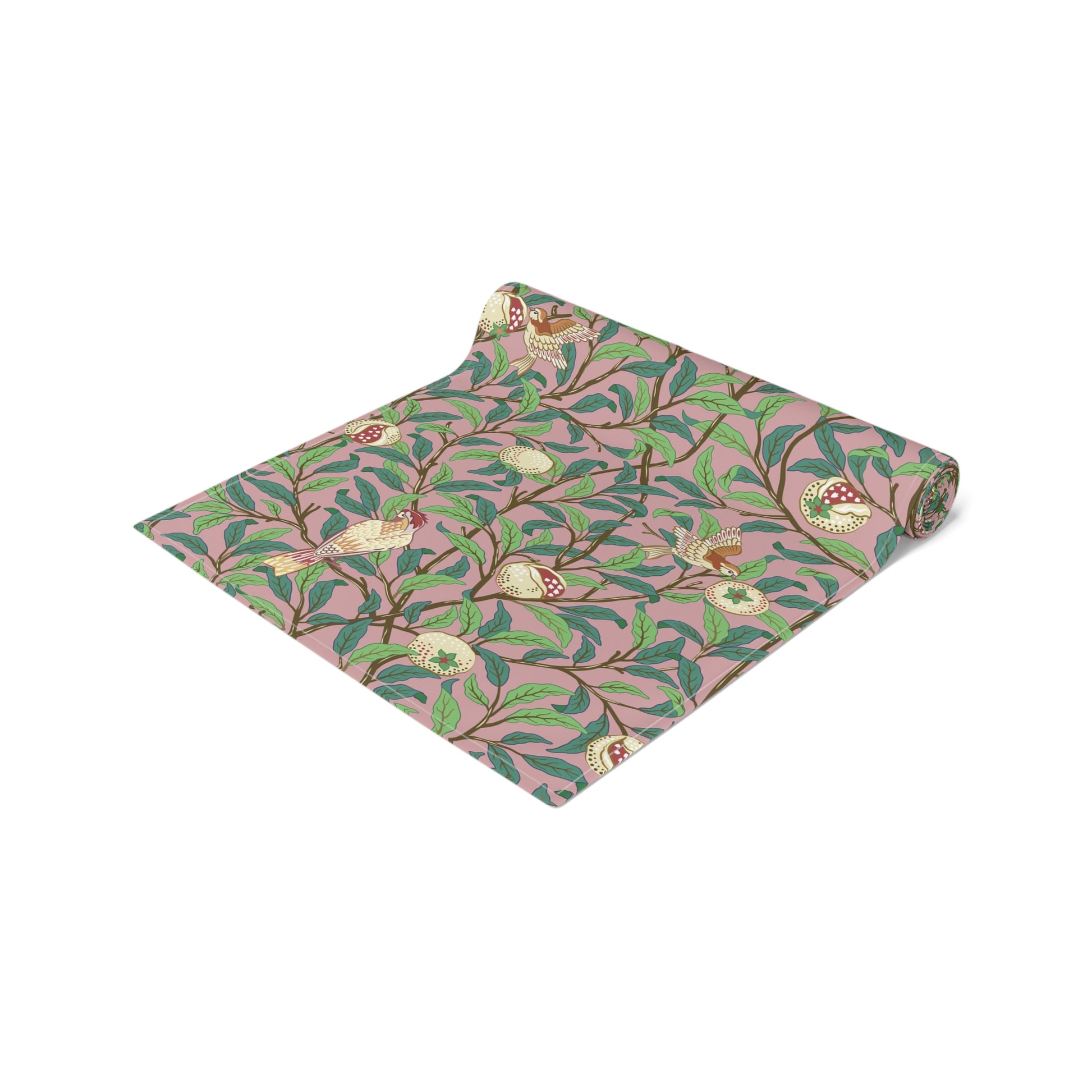 A table runner with a William Morris & Co Victorian-inspired bird and pomegranate pattern laid out on a dining table.