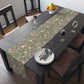 A table runner with a William Morris & Co Victorian-inspired bird and pomegranate pattern laid out on a dining table.