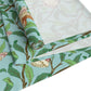 A tiffany blue table runner with a William Morris & Co floral and bird design laid out on a dining table with dishes and cutlery.