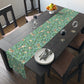 A tiffany blue table runner with a William Morris & Co floral and bird design laid out on a dining table with dishes and cutlery.