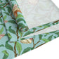 A tiffany blue table runner with a William Morris & Co floral and bird design laid out on a dining table with dishes and cutlery.