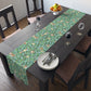 A tiffany blue table runner with a William Morris & Co floral and bird design laid out on a dining table with dishes and cutlery.