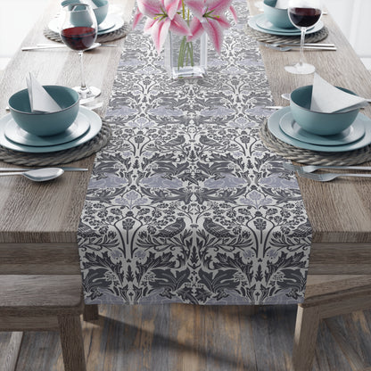 Dining table set with a patterned table runner, blue bowls, and pink flowers.