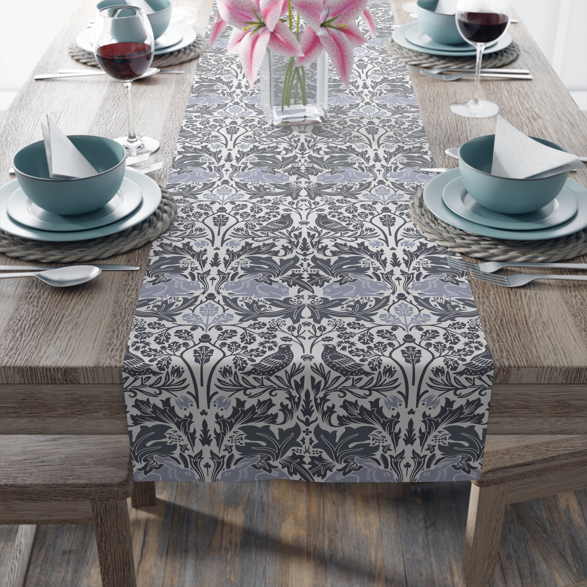 Dining table set with a patterned table runner, bowls, and glasses.