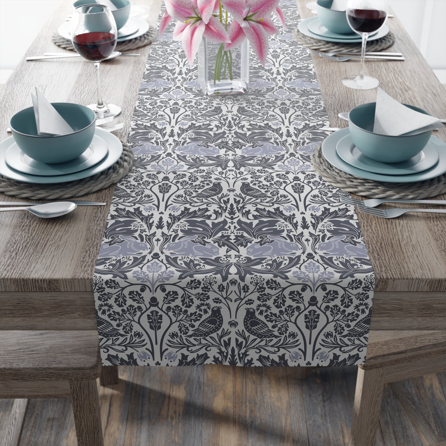 Table setting with a decorative table runner on a wooden table.