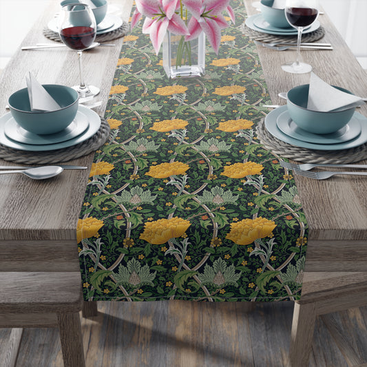 A yellow and green floral William Morris & Co patterned table runner with hemmed edges displayed on a dining table.