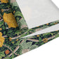 A yellow and green floral William Morris & Co patterned table runner with hemmed edges displayed on a dining table.