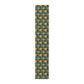 A yellow and green floral William Morris & Co patterned table runner with hemmed edges displayed on a dining table.