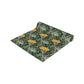 A yellow and green floral William Morris & Co patterned table runner with hemmed edges displayed on a dining table.
