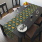 A yellow and green floral William Morris & Co patterned table runner with hemmed edges displayed on a dining table.