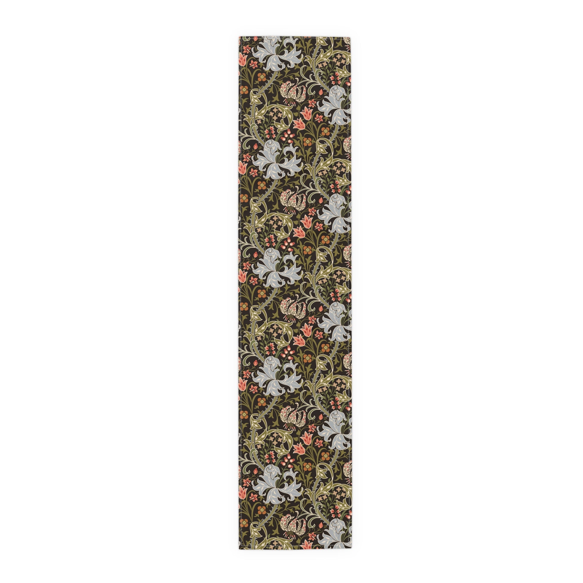A table runner with a floral William Morris & Co pattern in shades of green, gold, and other colours, laid out on a dining table with dishes and glasses arranged on top.