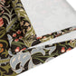 A table runner with a floral William Morris & Co pattern in shades of green, gold, and other colours, laid out on a dining table with dishes and glasses arranged on top.