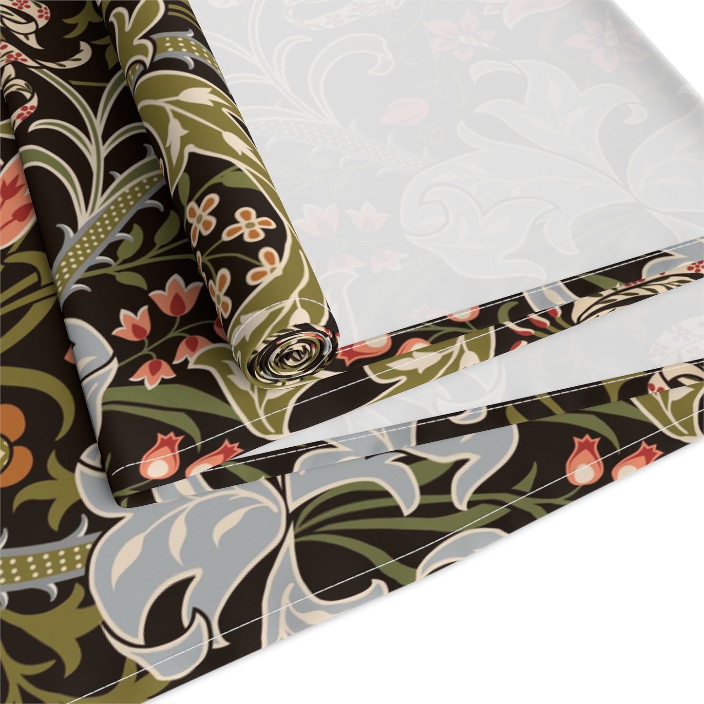 A table runner with a floral William Morris & Co pattern in shades of green, gold, and other colours, laid out on a dining table with dishes and glasses arranged on top.